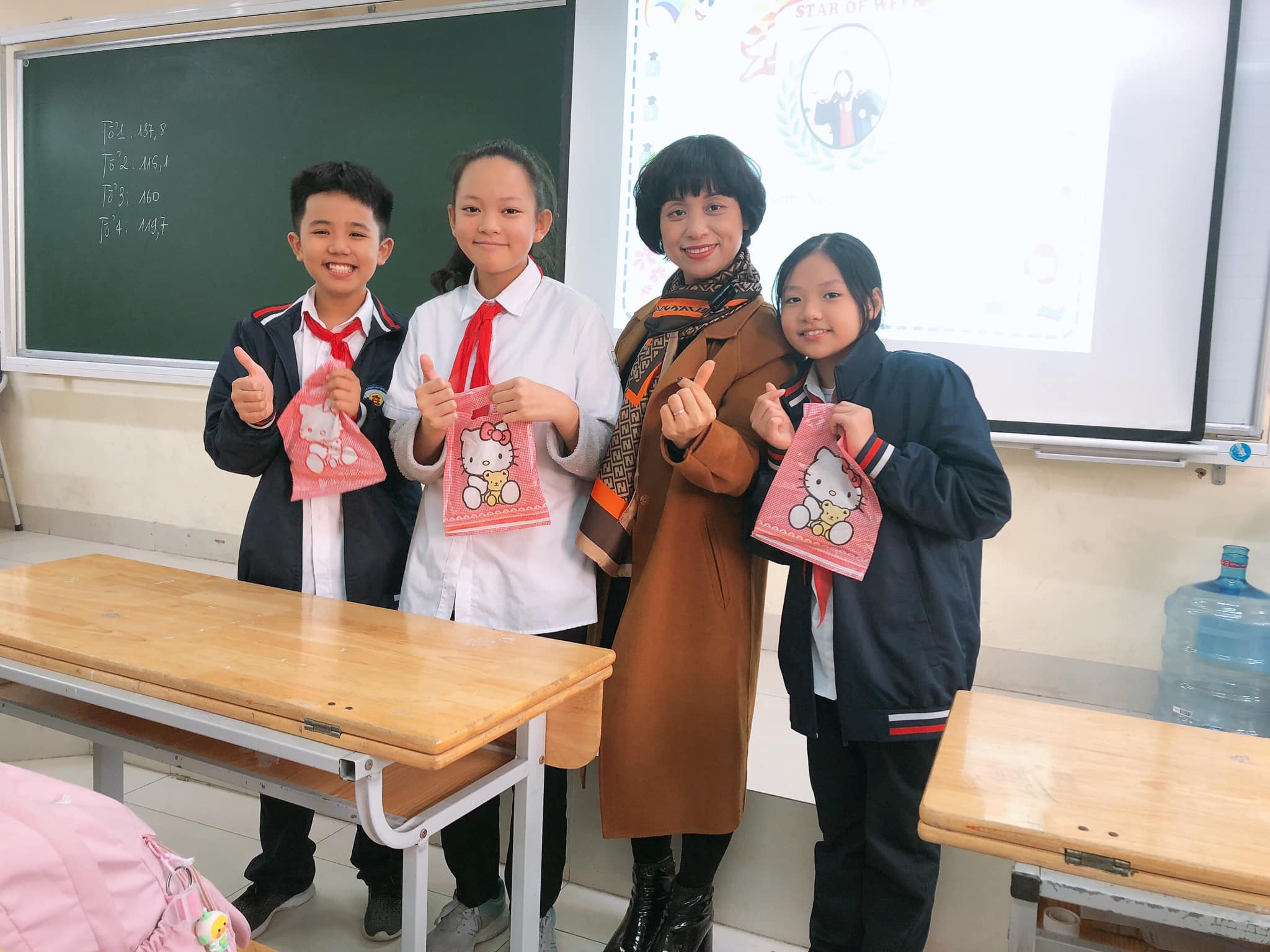 A group of people standing in a classroomDescription automatically generated