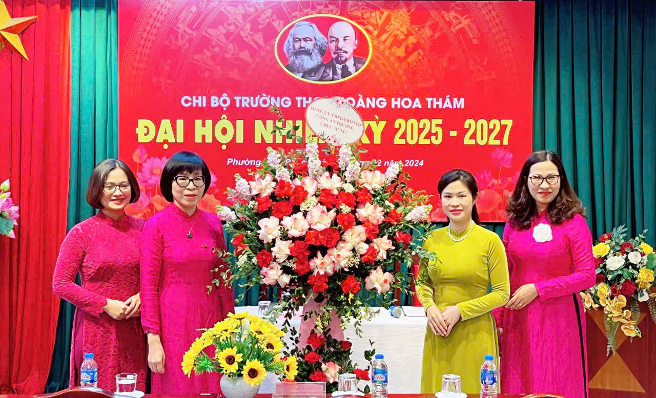 A group of women standing in front of a large bouquet of flowersDescription automatically generated