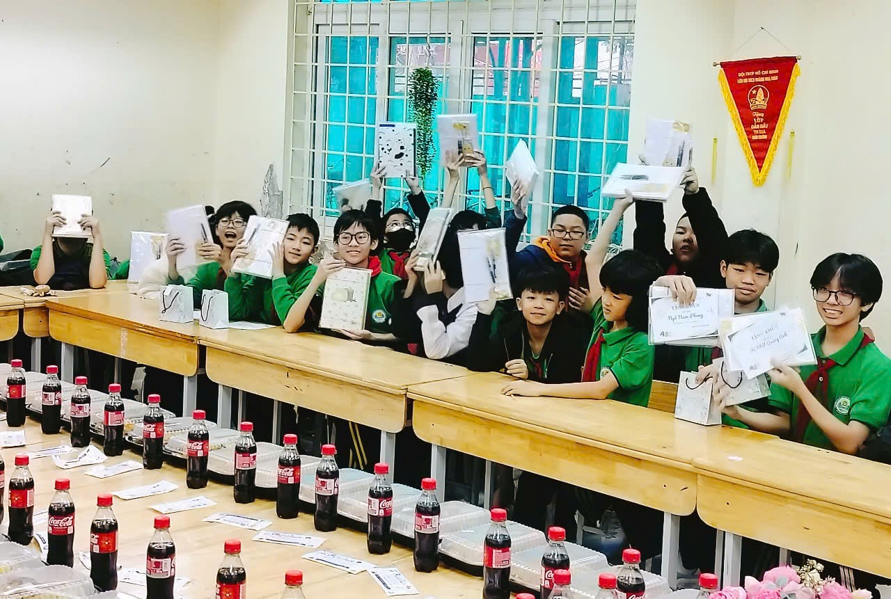 A group of people holding papers in a classroom

Description automatically generated