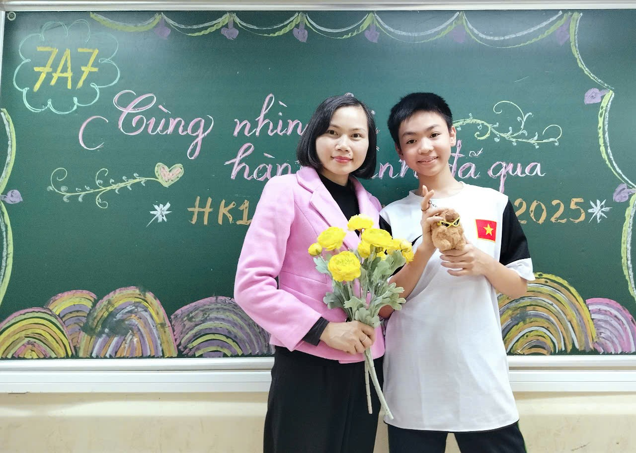 A child and child holding flowers and standing in front of a chalkboard

Description automatically generated