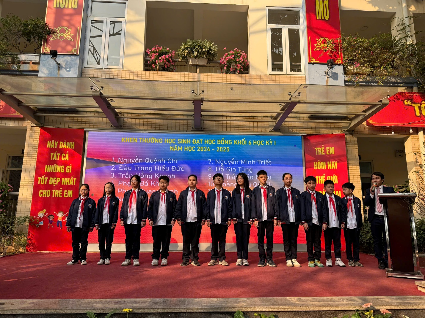A group of people standing in a rowDescription automatically generated