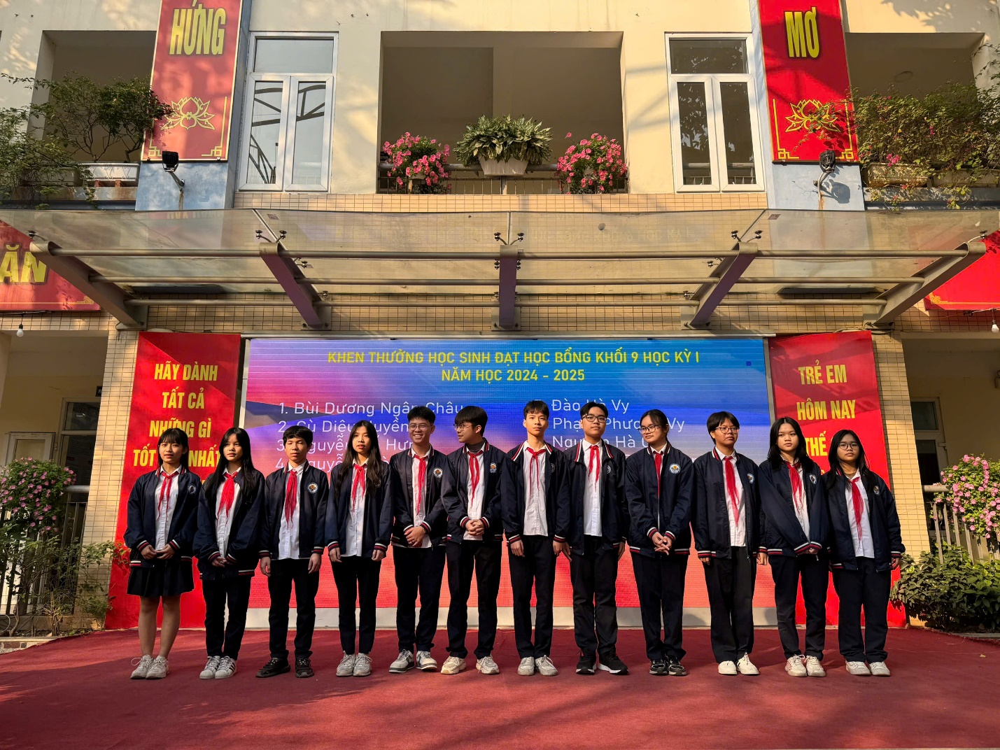 A group of people standing in a rowDescription automatically generated