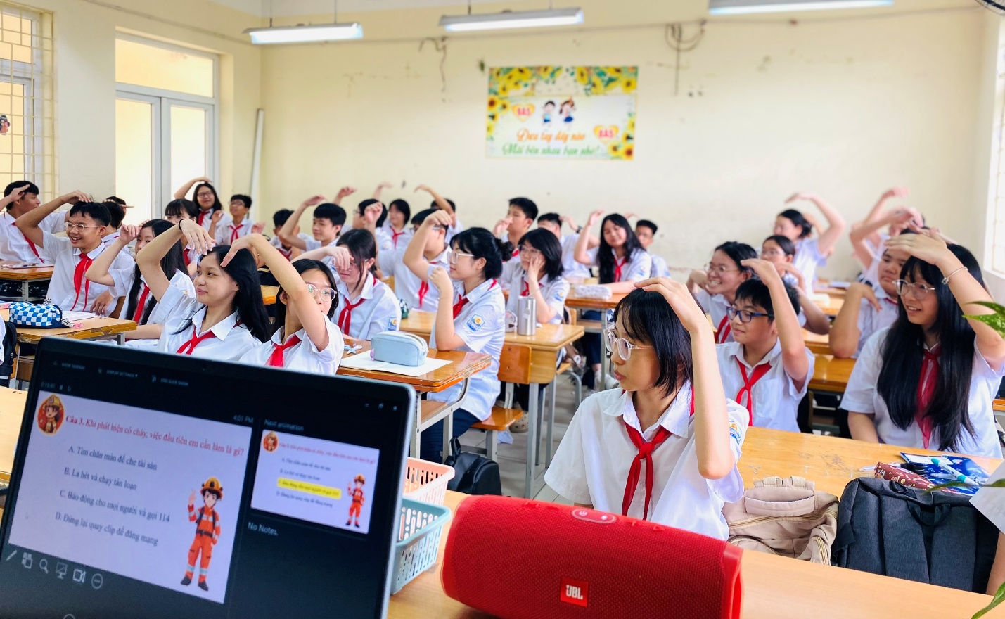 A group of students raising their hands in a classroom
AI-generated content may be incorrect.