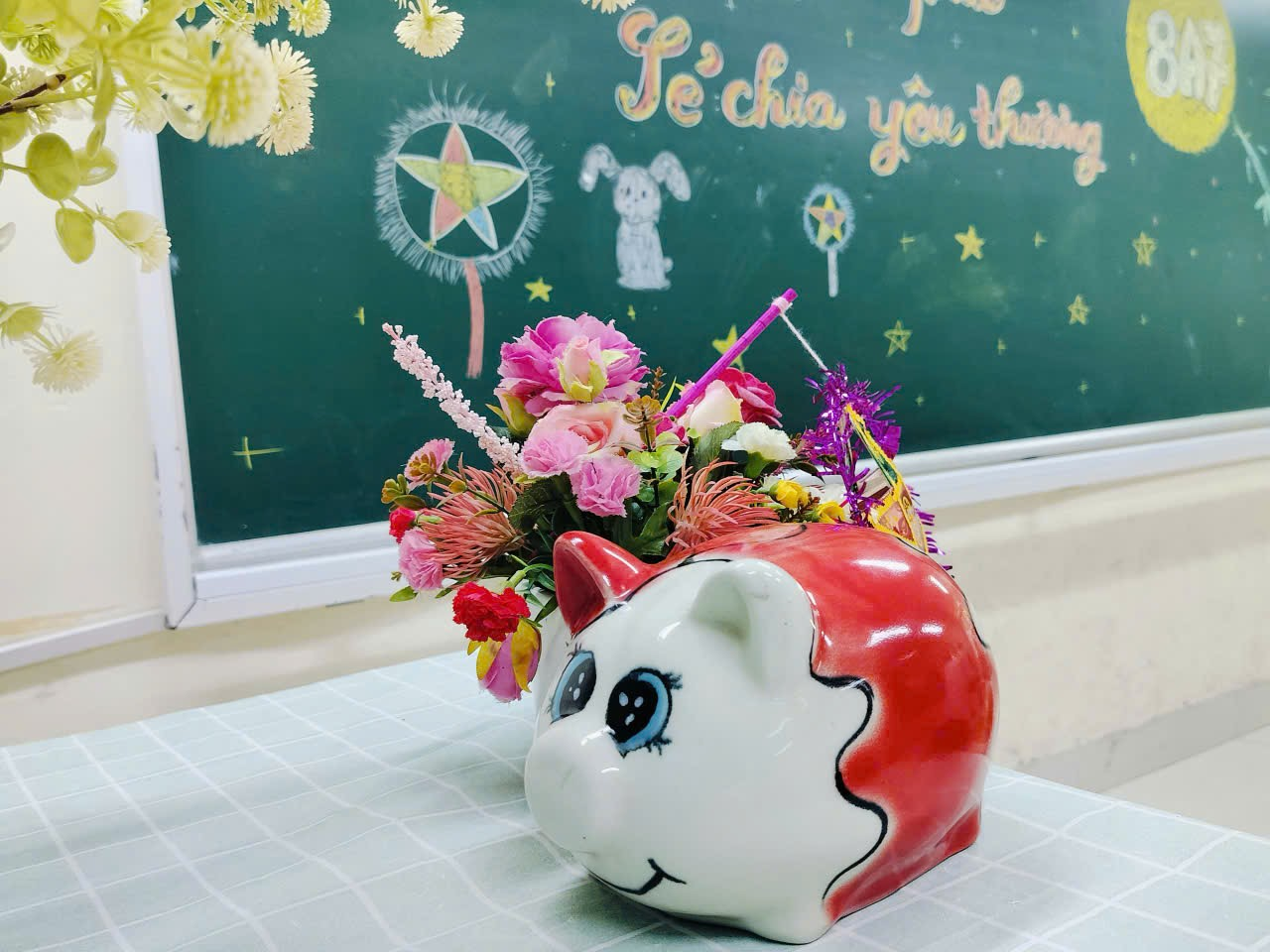A vase with flowers on a table
Description automatically generated