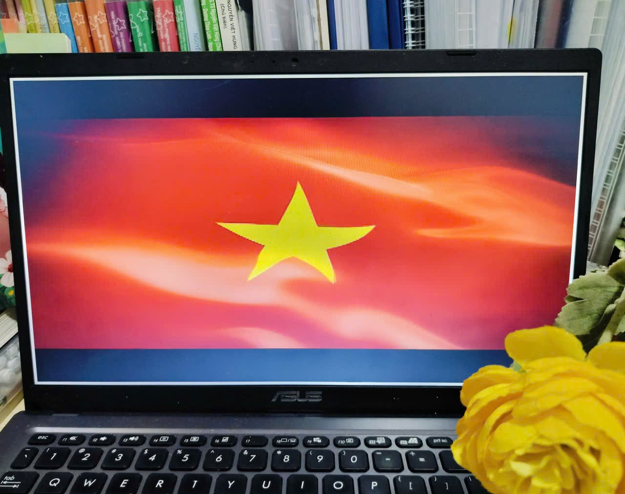 A computer with a yellow flower and a yellow star on the screen
Description automatically generated