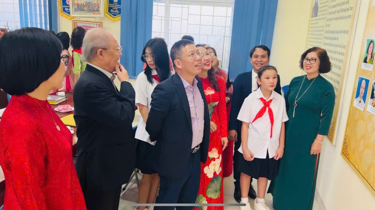 A group of people standing in a roomDescription automatically generated