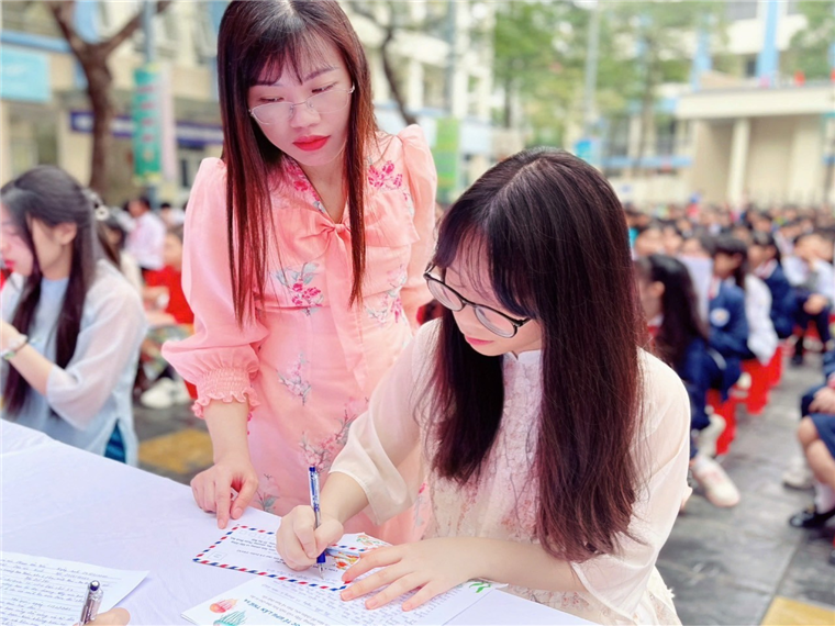 A group of women signing papers

Description automatically generated