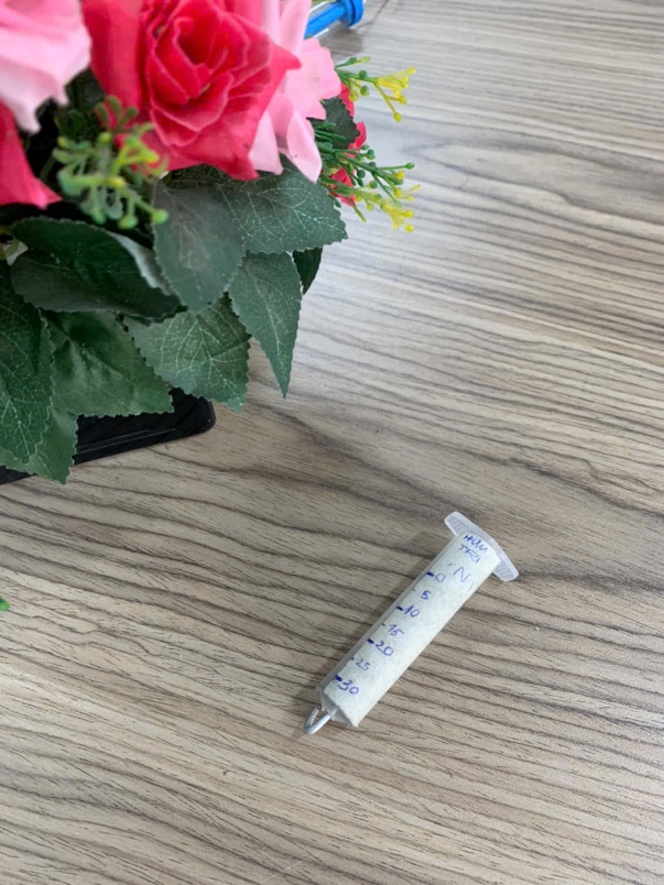 A syringe on a table next to a bouquet of flowers

AI-generated content may be incorrect.