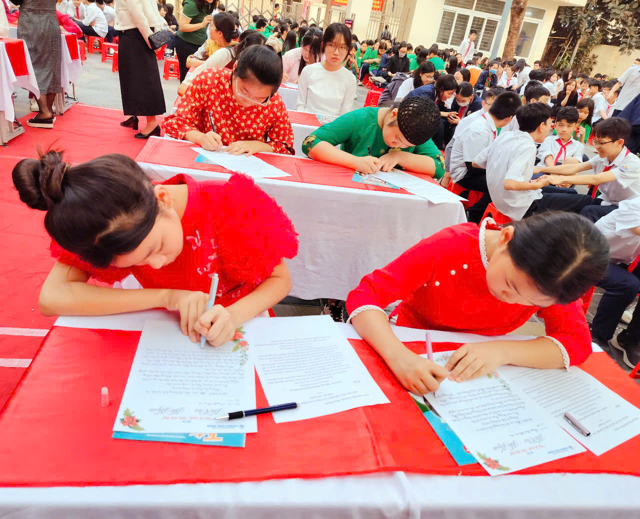 A group of people writing on paper

Description automatically generated