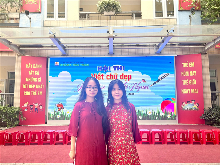 Two women standing in front of a stage

Description automatically generated