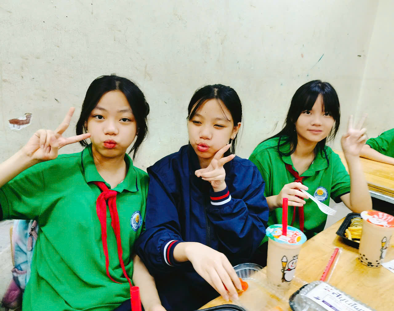 A group of girls sitting at a table with food and drinks

Description automatically generated