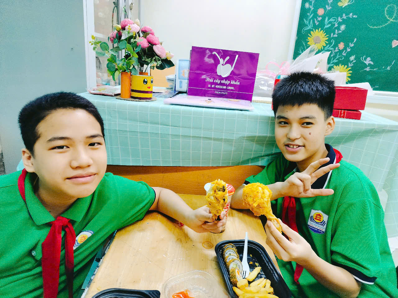 Two boys sitting at a table eating food

Description automatically generated