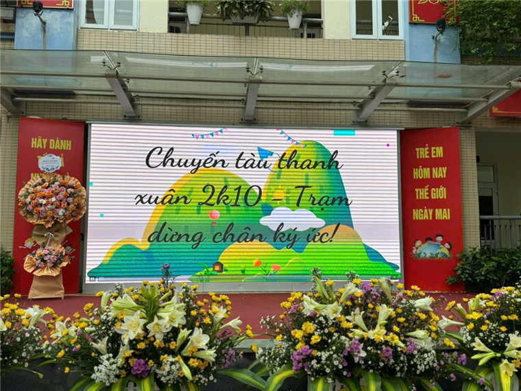 A large screen with flowers in front of a buildingAI-generated content may be incorrect.