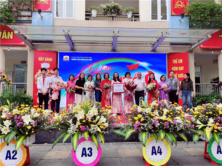 A group of people standing in front of a large bannerAI-generated content may be incorrect.
