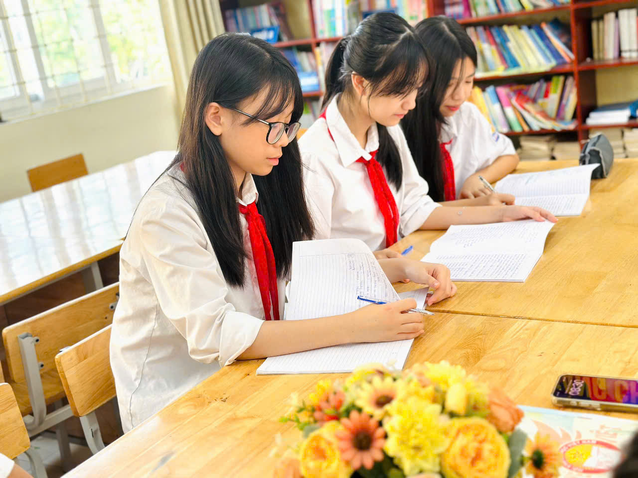 A group of girls in a libraryDescription automatically generated