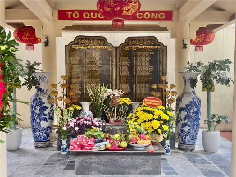 A display of flowers and vases in front of a plaqueAI-generated content may be incorrect.