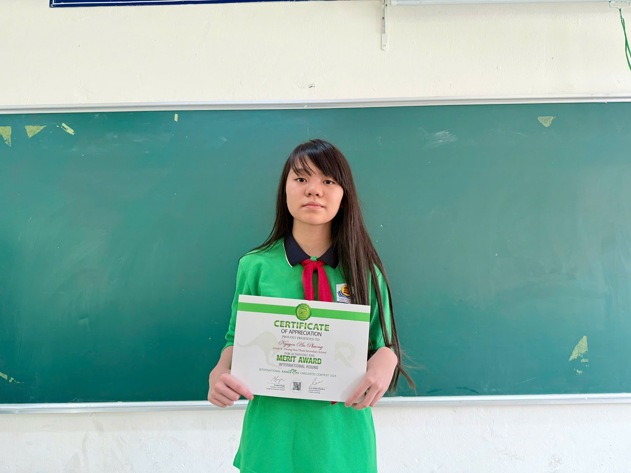 A person holding a certificate in front of a chalkboard
AI-generated content may be incorrect.