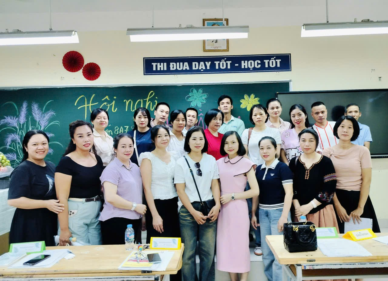 A group of people standing in a classroom
Description automatically generated