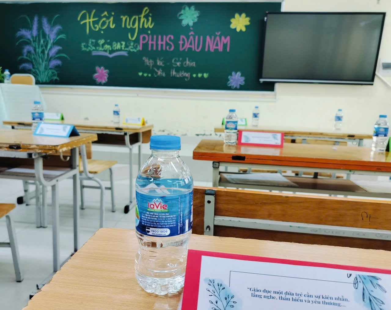 A water bottle on a desk
Description automatically generated