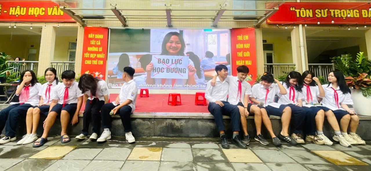 A group of people sitting on a bench
Description automatically generated