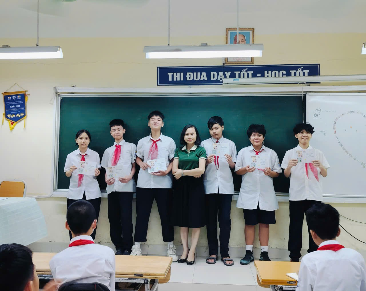 A group of people standing in a classroom
Description automatically generated