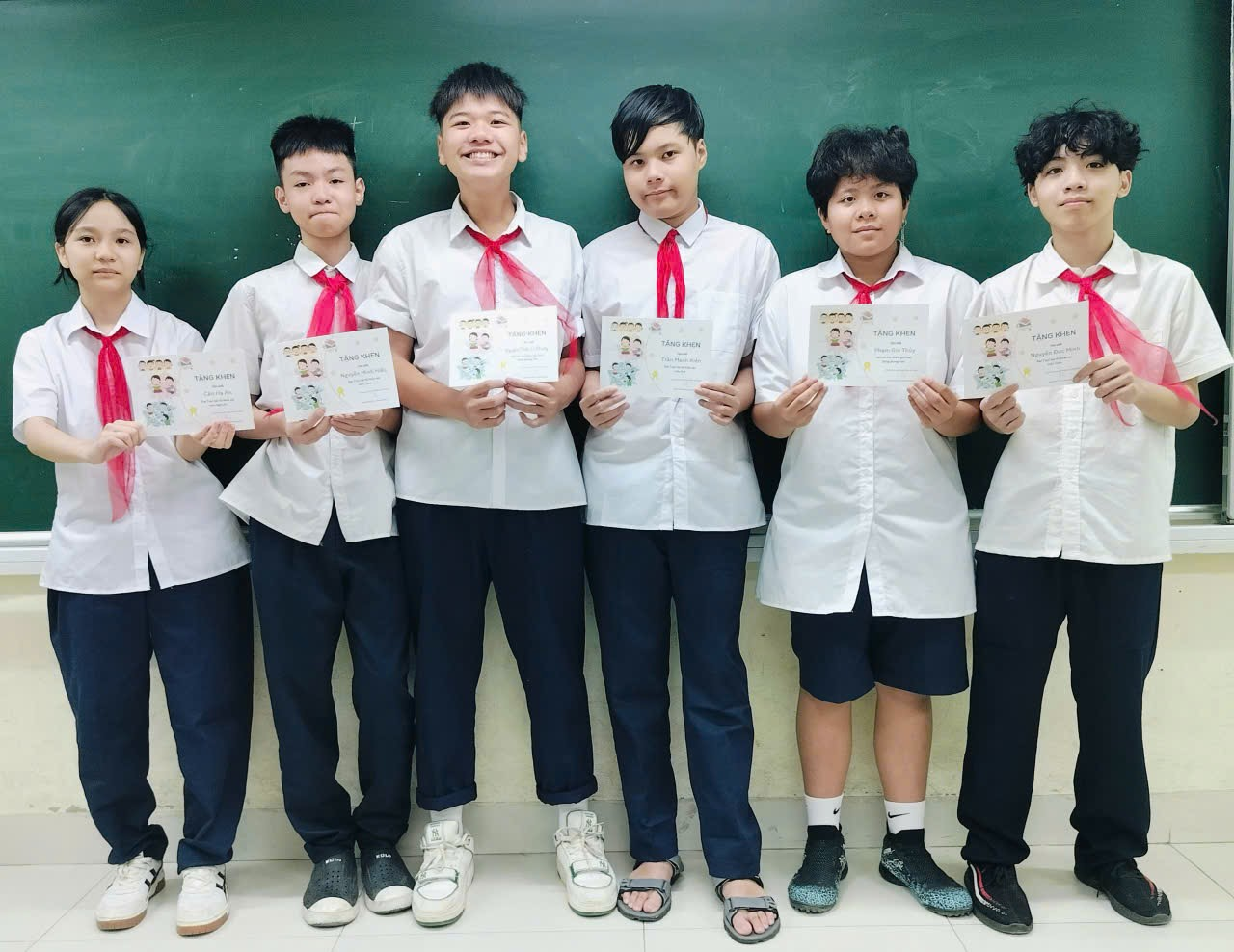 A group of people holding paper
Description automatically generated