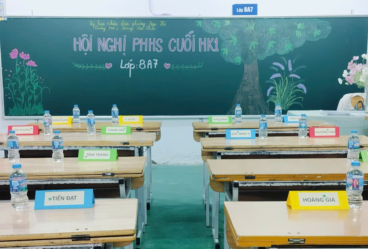 A classroom with empty desks and water bottles

Description automatically generated