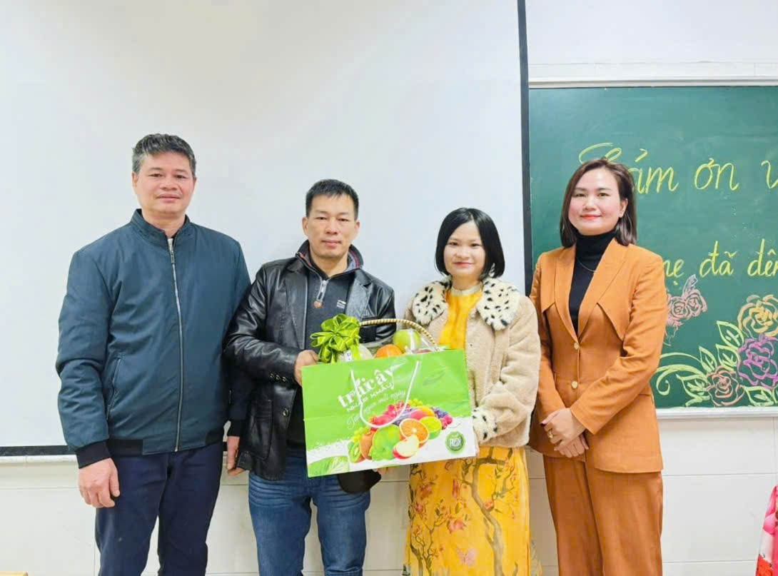 A group of people standing in front of a chalkboard

Description automatically generated