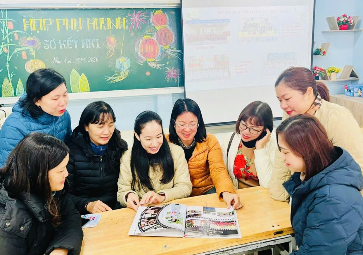 A group of people sitting around a table looking at a book

Description automatically generated