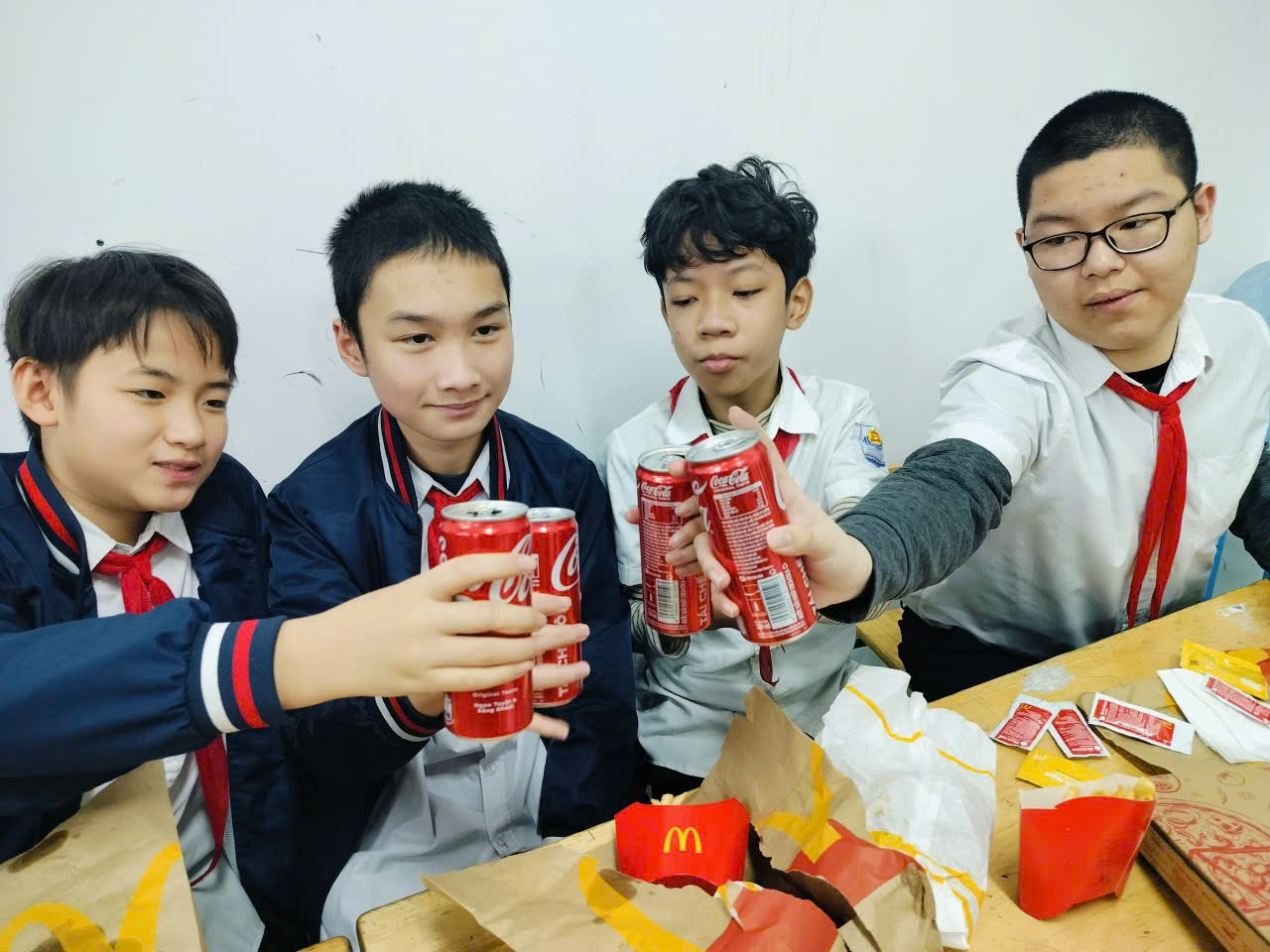 A group of boys holding up cans

Description automatically generated