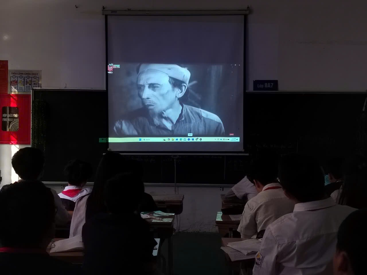 A group of people sitting in front of a projector screen

Description automatically generated