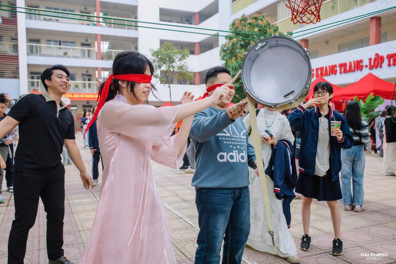 A person blindfolded with a drum and other people

Description automatically generated