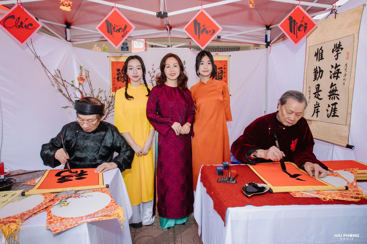 A group of people standing around tables

Description automatically generated