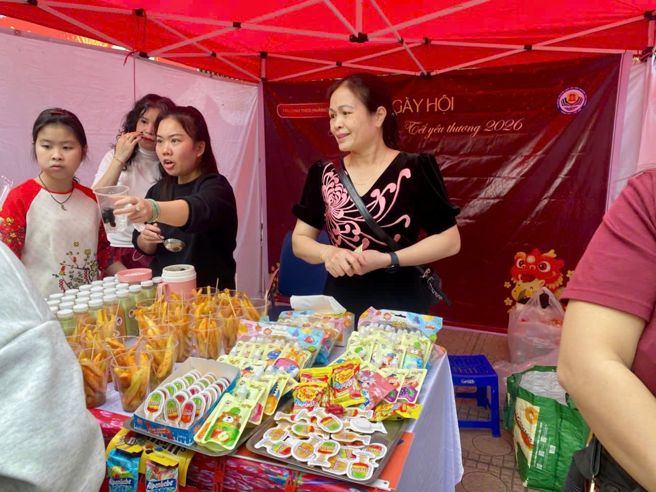 A group of women standing in a tent

Description automatically generated