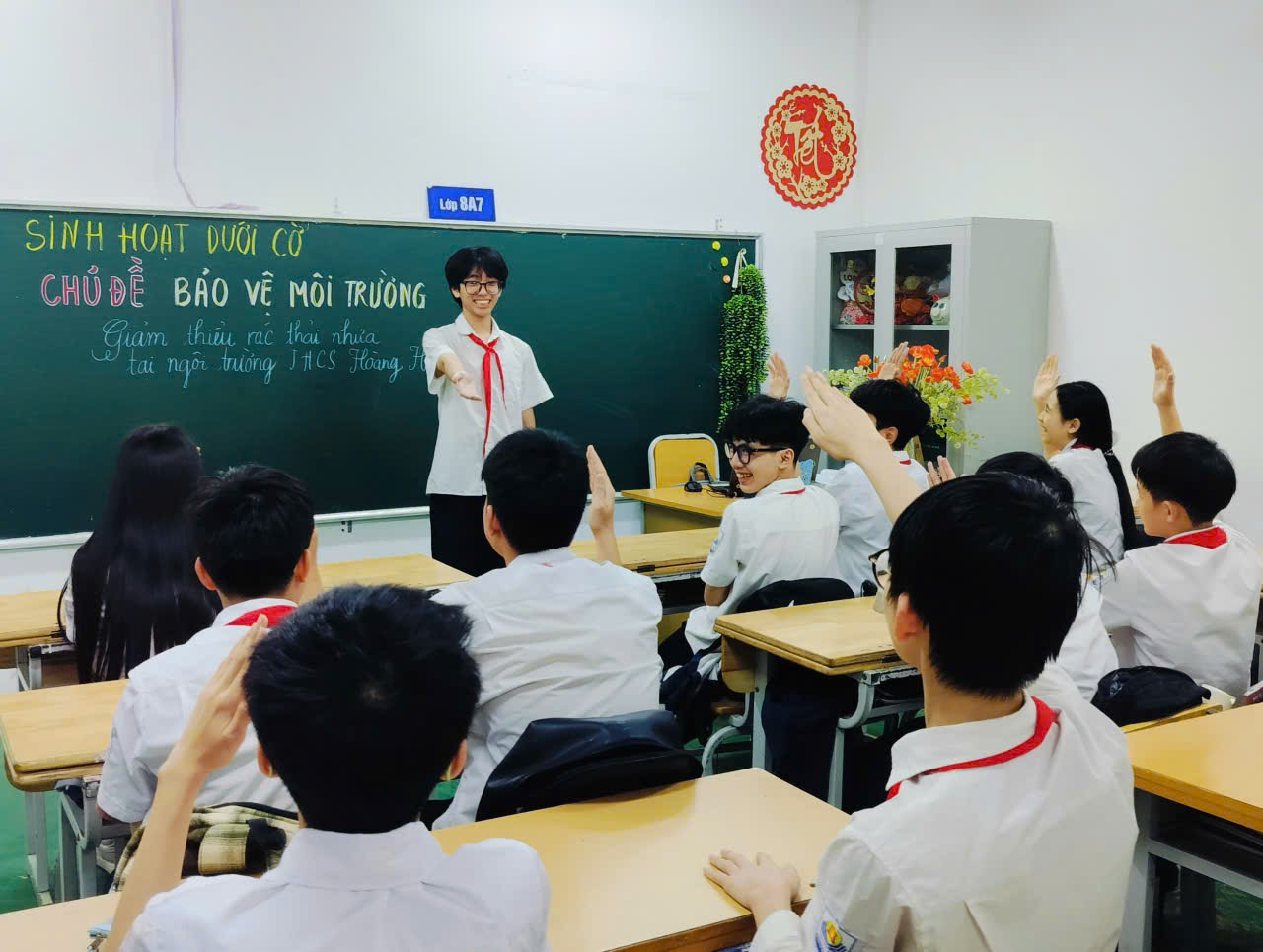 A group of people in a classroom raising their hands

Description automatically generated
