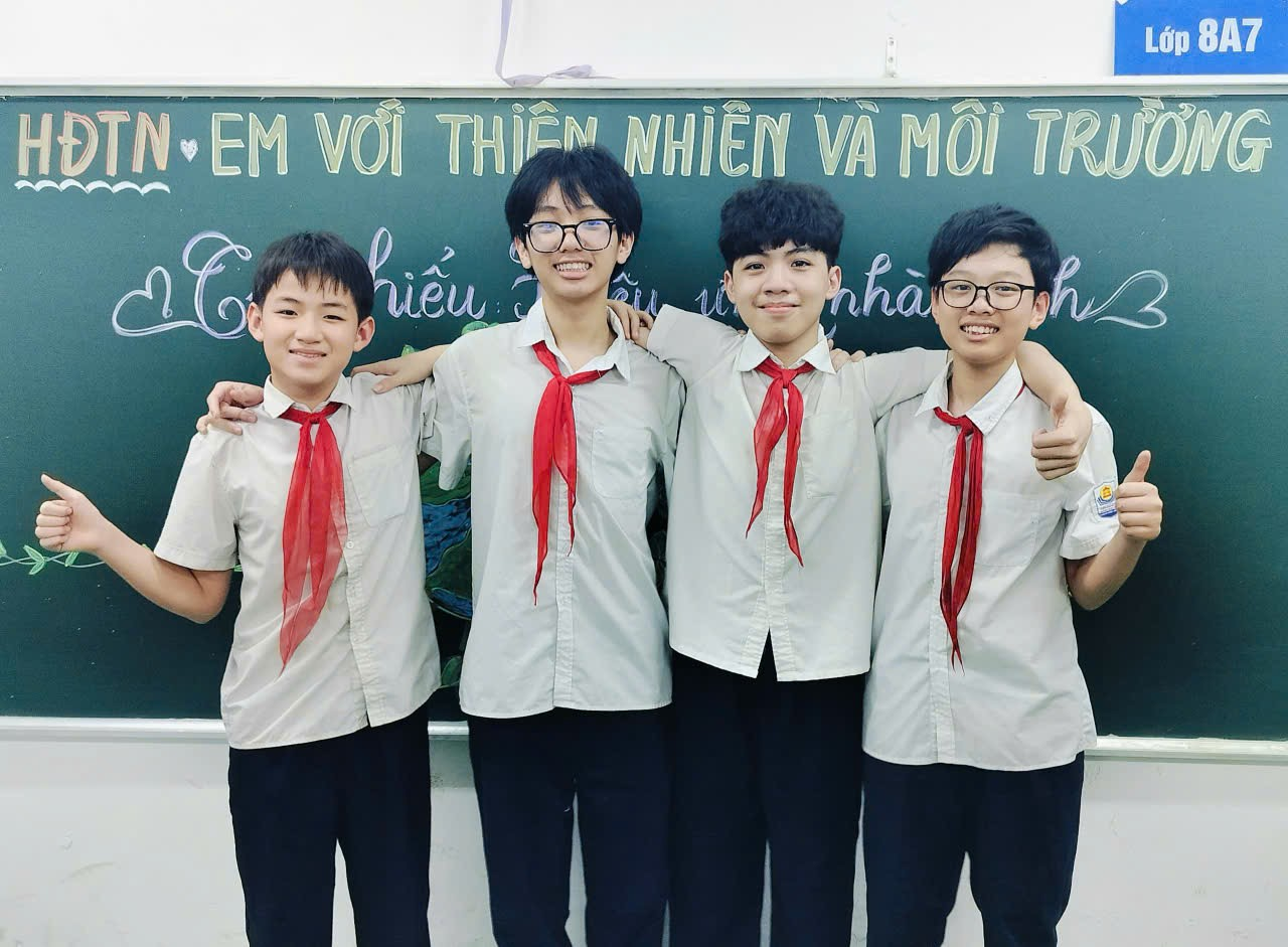 A group of boys in uniform standing in front of a chalkboard

Description automatically generated