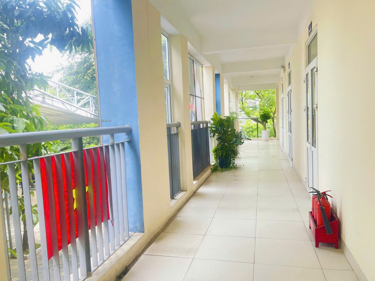 A hallway with a red luggage on it

Description automatically generated