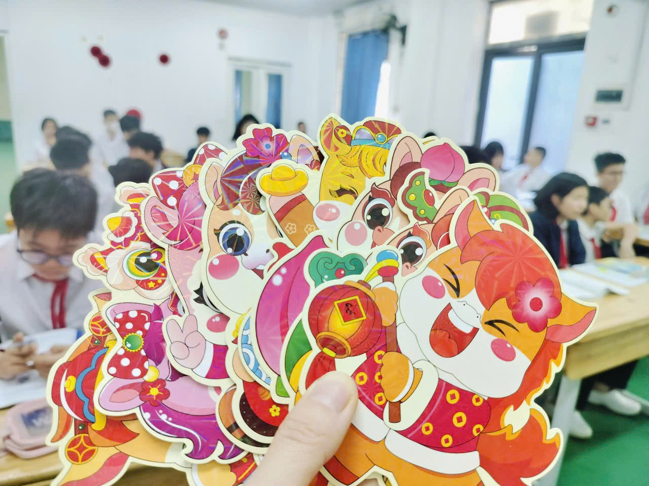 A hand holding a group of cartoon characters
Description automatically generated