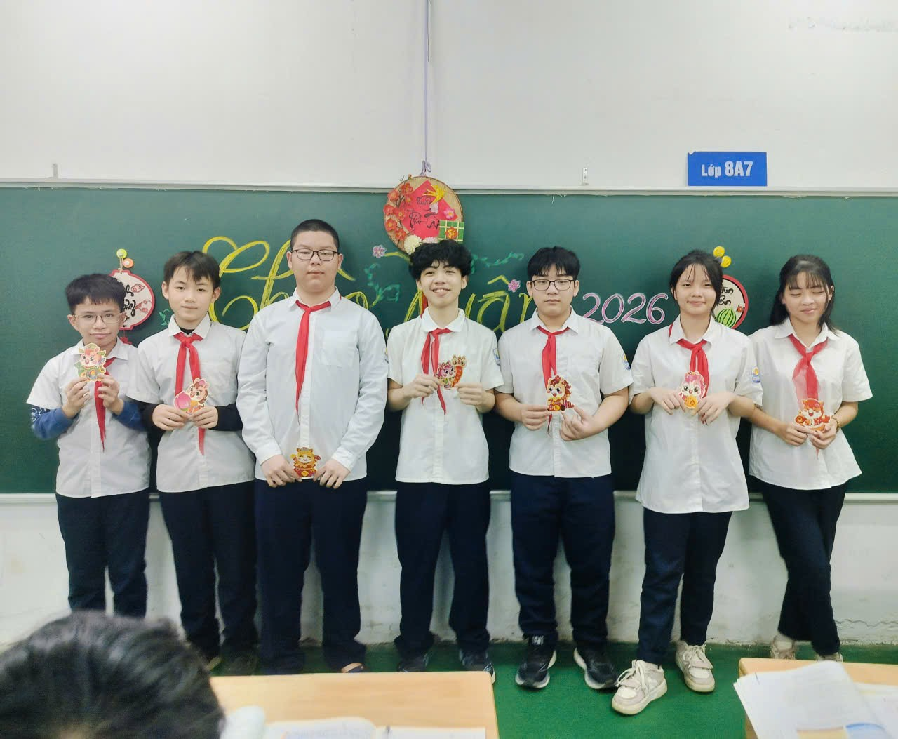 A group of people standing in front of a chalkboard
Description automatically generated