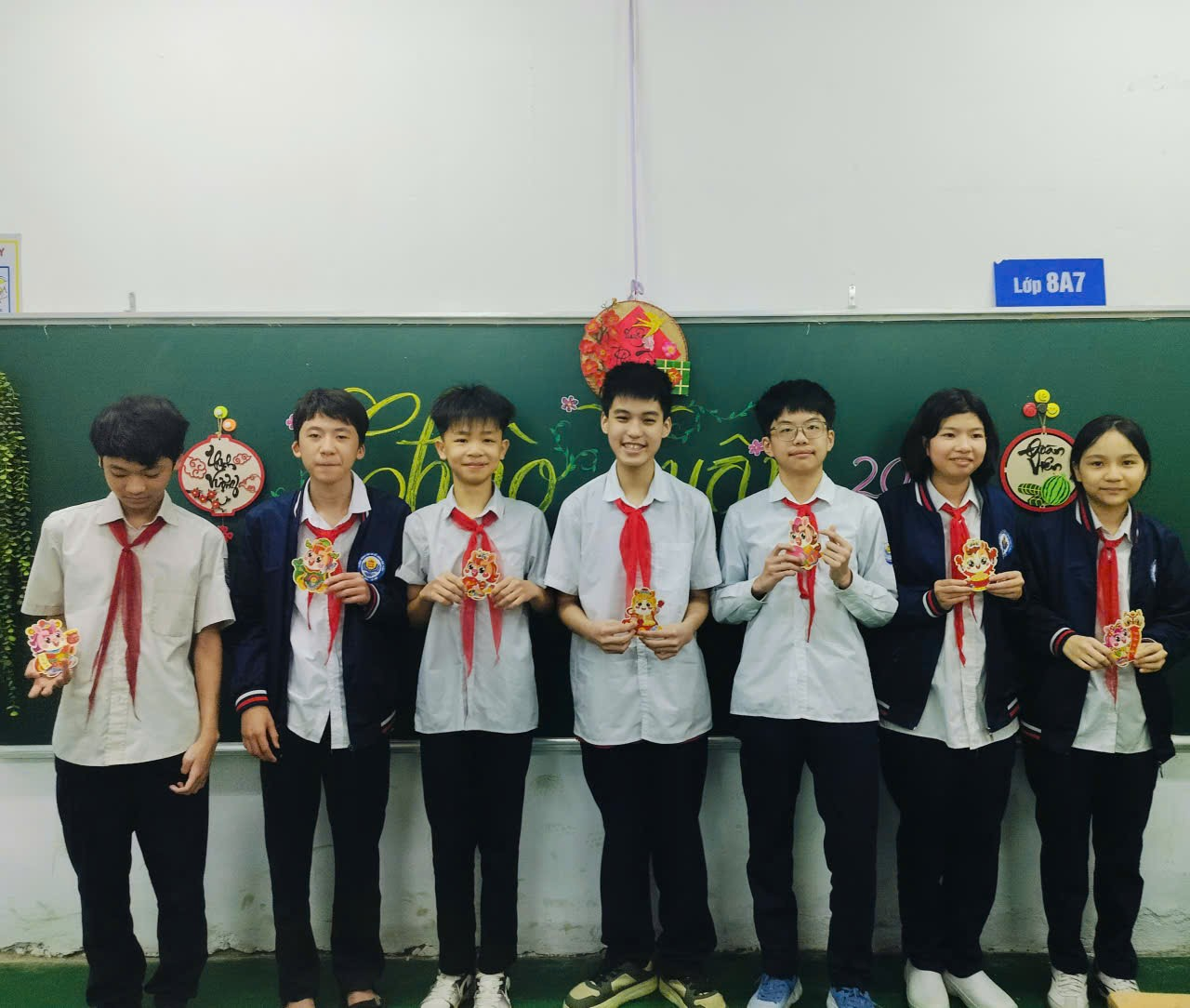 A group of people standing in front of a chalkboard
Description automatically generated