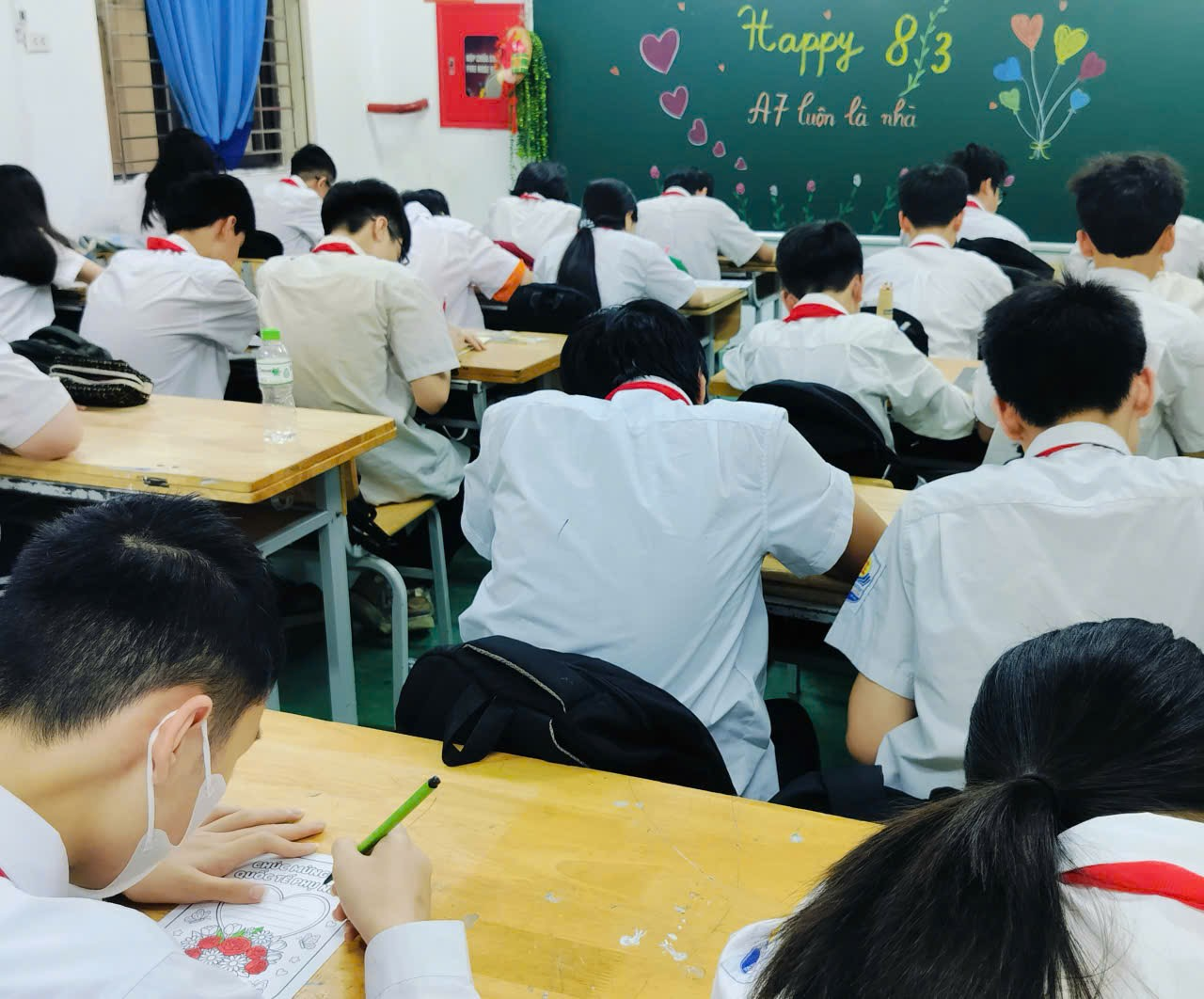 A group of students sitting at desks in a classroom
Description automatically generated