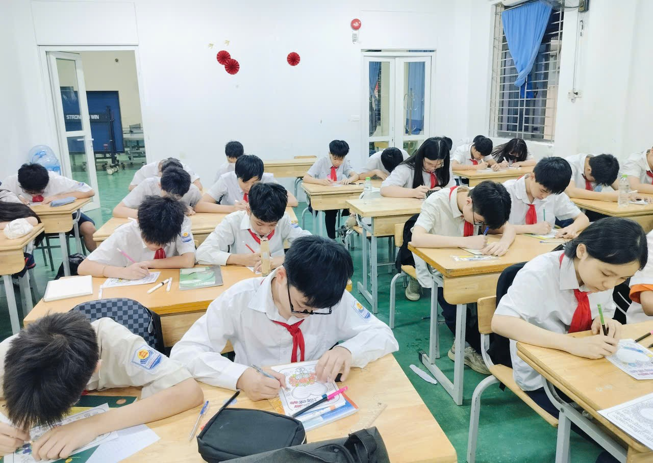 A group of students sitting at desks in a classroom
Description automatically generated