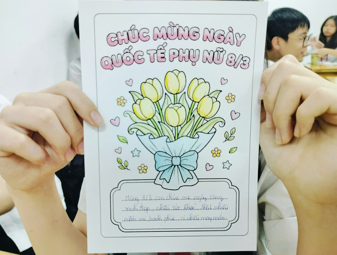A person holding a paper with flowers
Description automatically generated