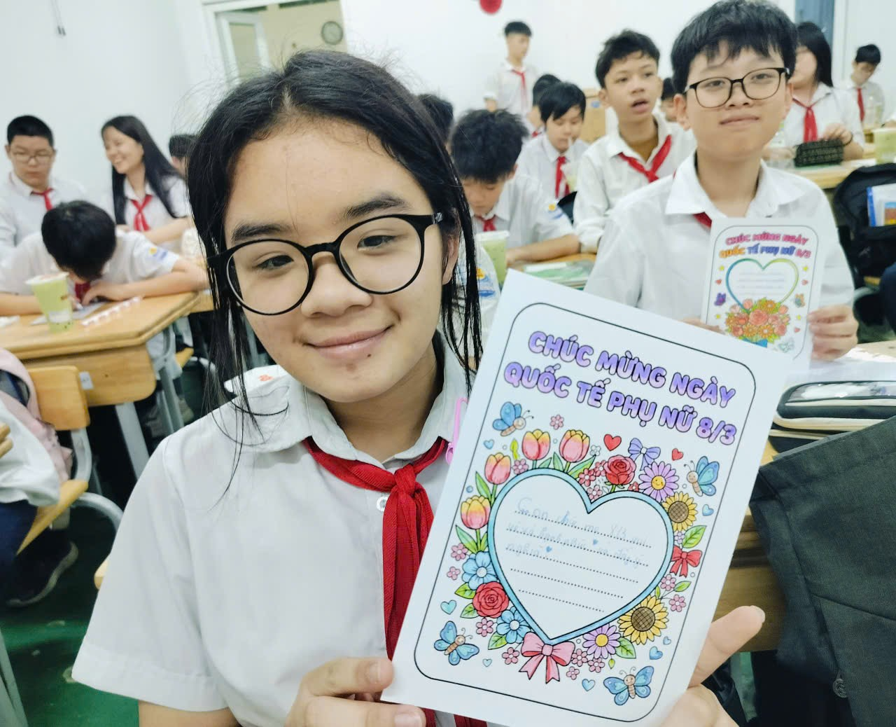 A child holding a piece of paper
Description automatically generated