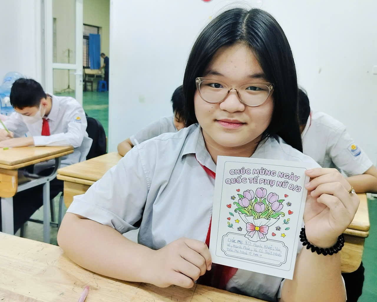 A child holding a piece of paper
Description automatically generated