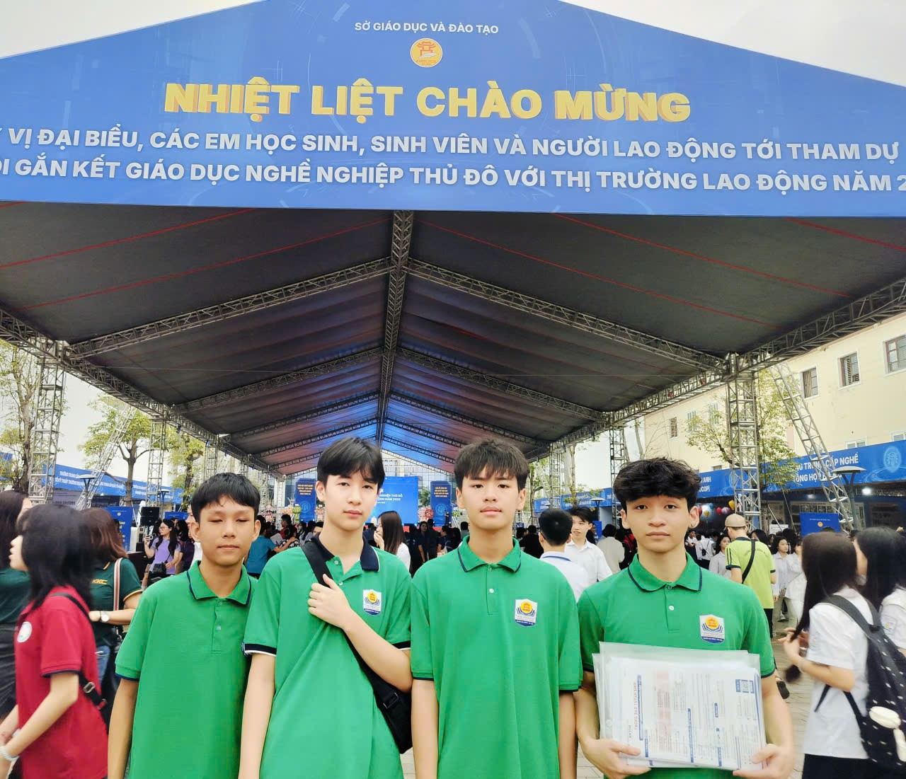 A group of people standing under a canopy

Description automatically generated