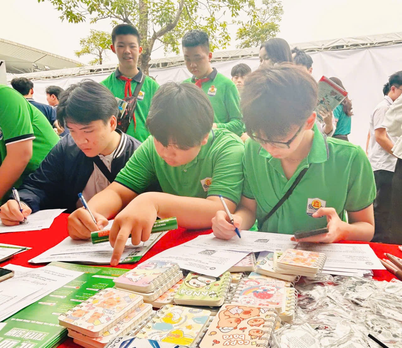 A group of people sitting at a table writing on papers

Description automatically generated