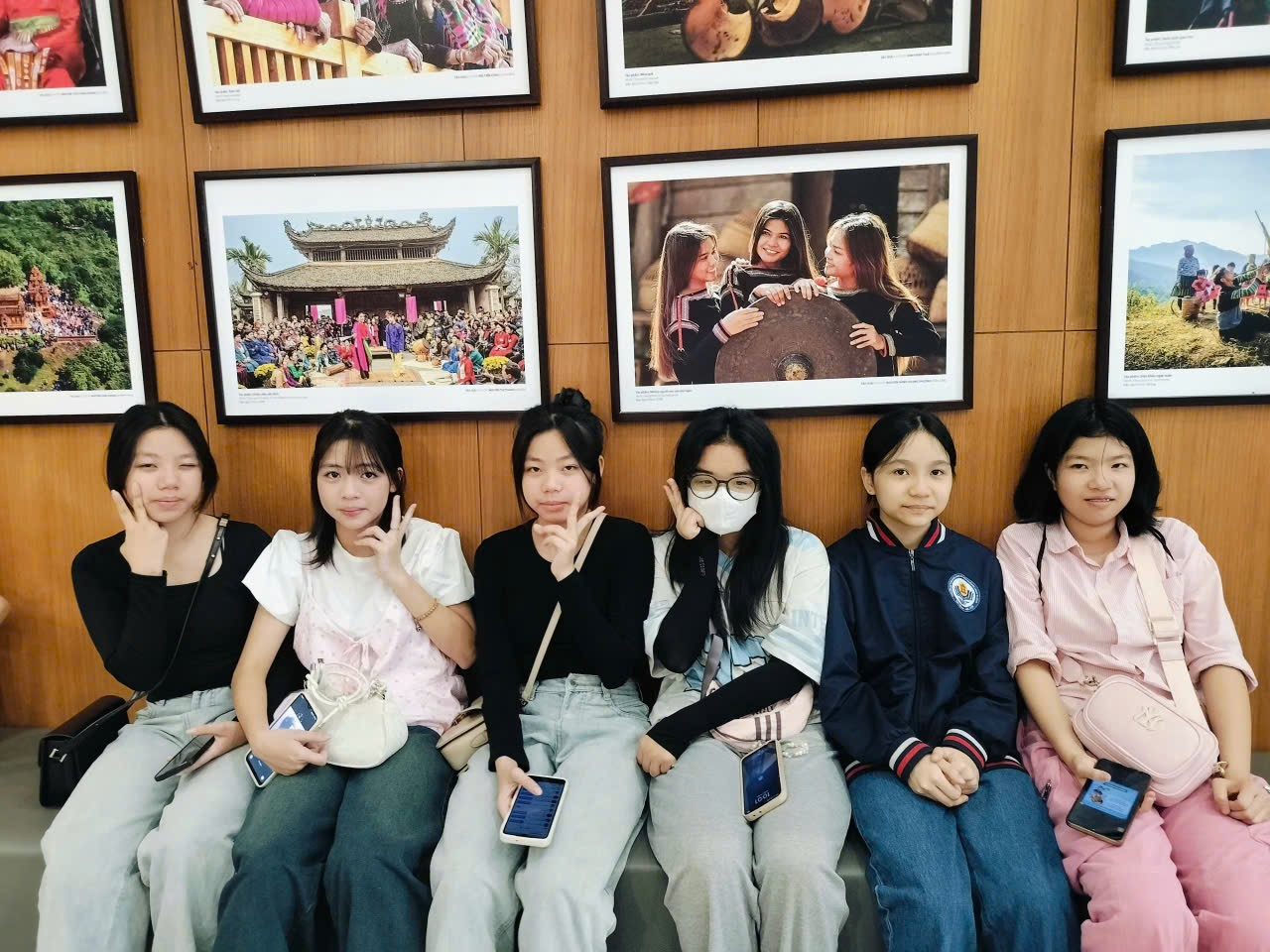 A group of women sitting on a bench
Description automatically generated