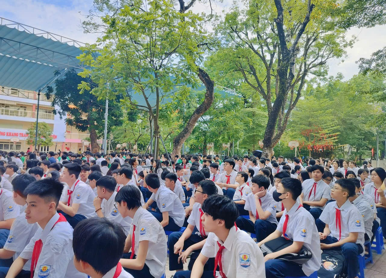 A group of people sitting on the groundDescription automatically generated