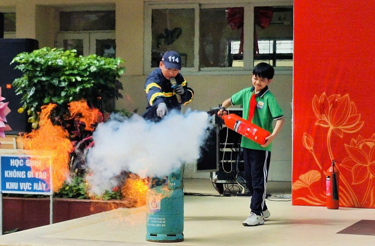 A child putting out a fire extinguisherDescription automatically generated